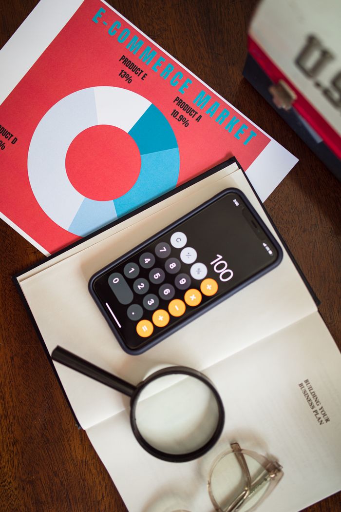 services-bg Overhead view of e-commerce chart with smartphone calculator and magnifying glass on a table.